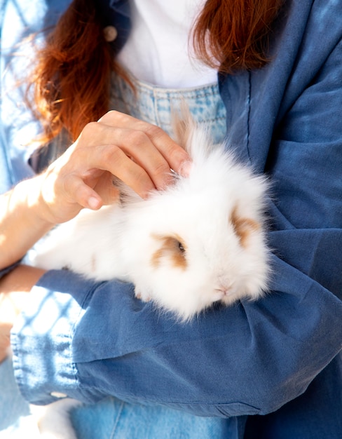 Photo gratuite agricultrice tenant un lapin blanc