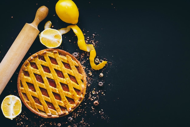 Agrumes et rouleau à pâtisserie près de tarte