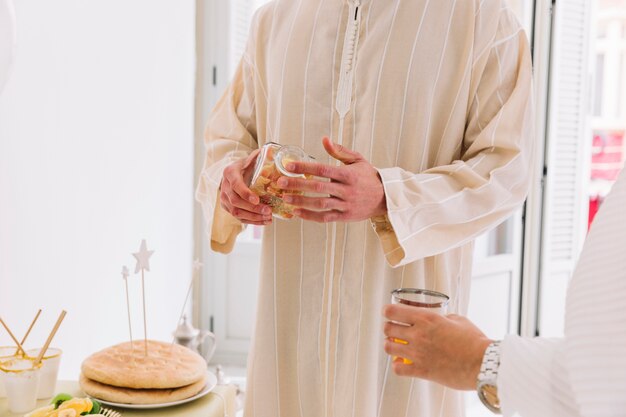 Aïd al-fitr concept avec homme tenant un pot de biscuits