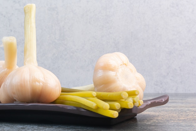 Photo gratuite ail fermenté et bâtonnets sur un plateau