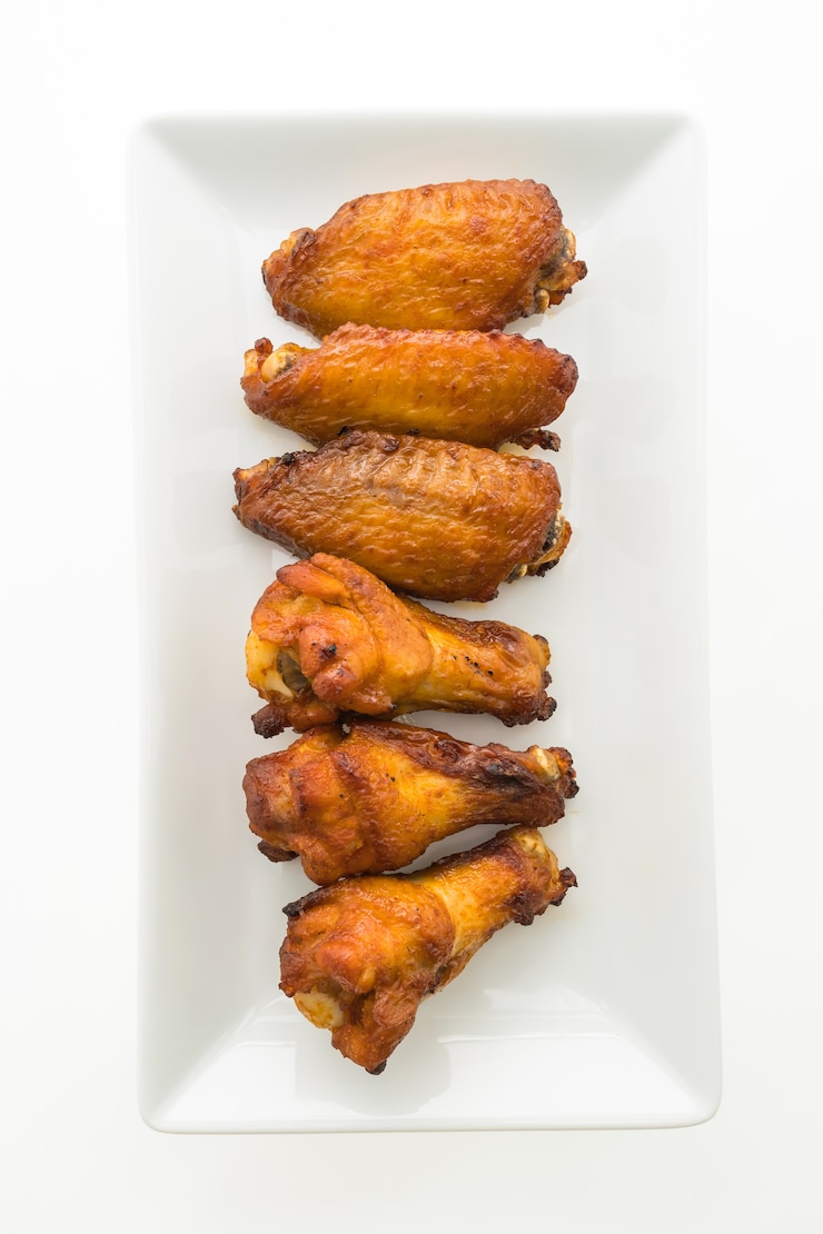 Photo gratuit aile de poulet grillée en assiette blanche
