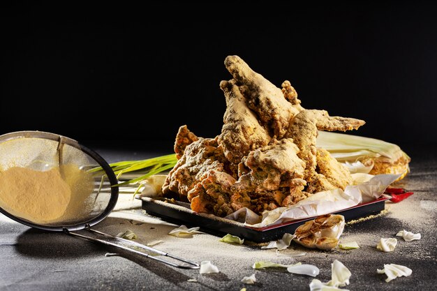 Ailes de poulet délicieusement cuites et assaisonnées à l'ail sur la table sous les lumières