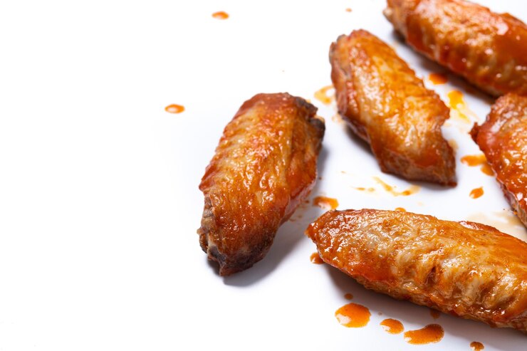 Photo gratuit ailes de poulet épicées de buffle avec sauce au poivre de cayenne isolée sur fond blanc