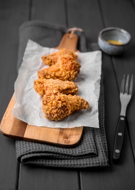 Ailes de poulet frit à angle élevé sur une planche à découper