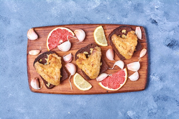 Ailes de poulet frit sur une planche de bois sur bleu