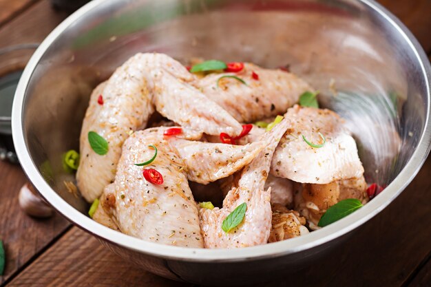 Photo gratuite ailes de poulet marinées crues préparées à l'asiatique avec du miel, de l'ail, de la sauce soja et des herbes