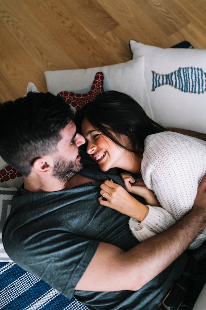 Photo gratuite aimer le jeune couple couché sur le plancher de bois franc