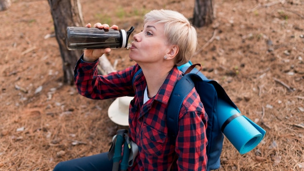 Photo gratuite aîné femme touriste eau potable pour l'hydratation