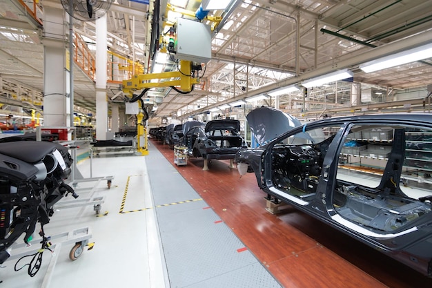 Ajouter des détails à la carrosserie de la voiture L'équipement robotique fait l'assemblage de la voiture L'assemblage de la voiture moderne à l'usine