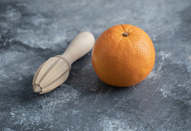 Photo gratuite un alésoir orange et bois sur table en marbre.