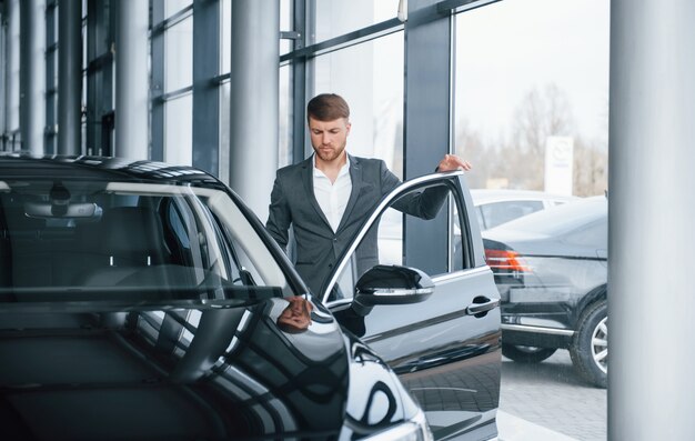 Allons au boulot. Homme d'affaires barbu élégant et moderne dans le salon automobile