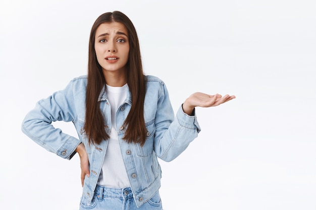 Alors quoi, je m'en fiche. Fille arrogante à l'air sérieux, levant une main sur le côté et semblant confuse, essayant de comprendre quel est ton point, se plaignant ou se disputant avec quelqu'un, fond blanc