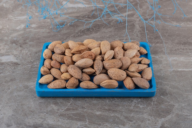 Amandes croustillantes sur le plateau sur la surface en marbre