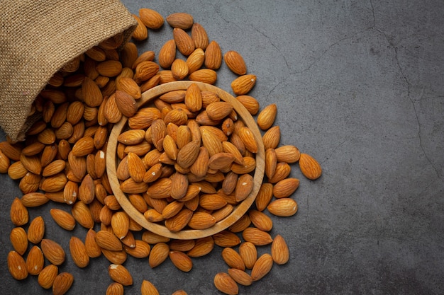 Photo gratuite amandes dans un bol sur fond sombre