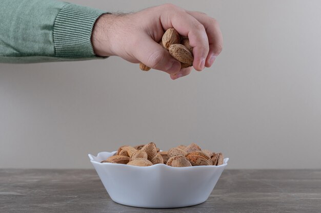 Amandes délicieuses dans le bol sur la surface en marbre