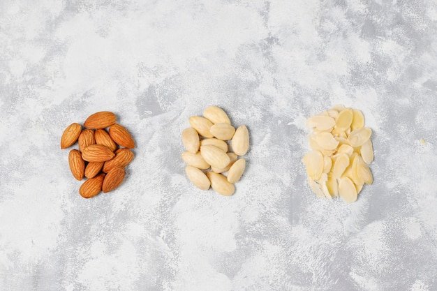 Photo gratuite amandes entières pelées (blanchies) et non blanchies sur béton gris