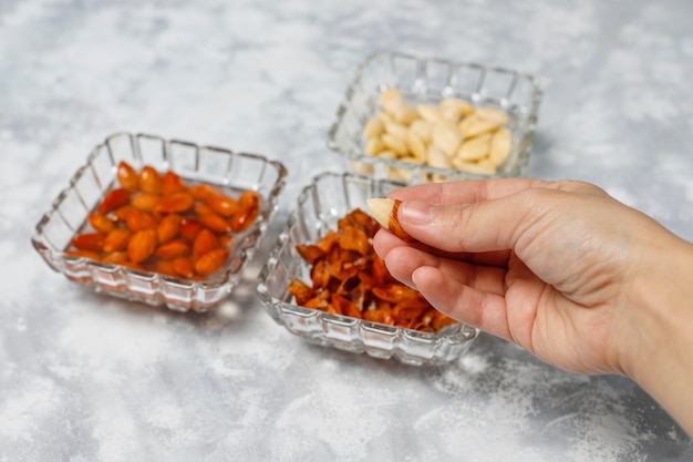 Amandes Entières Pelées (blanchies) Et Non Blanchies Dans Des Bols En Céramique Sur Du Béton Gris