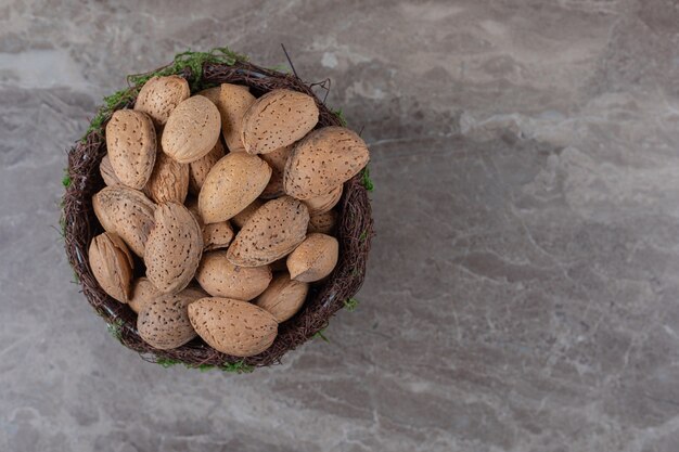 Amandes savoureuses dans un bol sur la surface en marbre