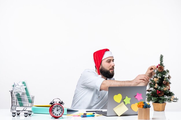 Ambiance de Noël avec un jeune adulte confus avec le père noël décorant son arbre de noël