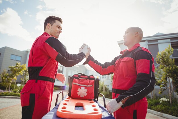 Ambulanciers souriants debout avec les bras croisés