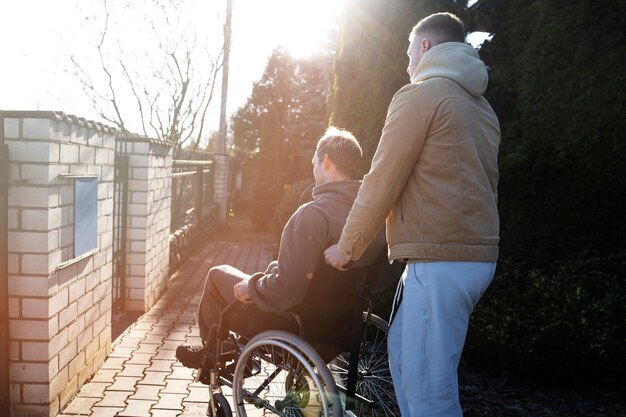 Ami aidant un homme handicapé à coup moyen