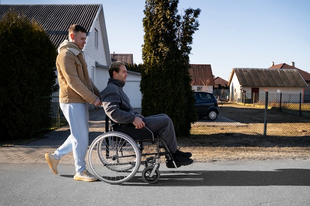 Ami aidant un homme handicapé à plein coup