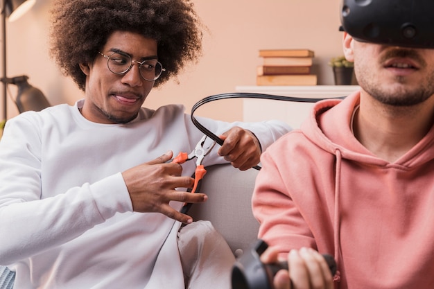 Photo gratuite ami jouant une farce sur un ami avec un casque virtuel