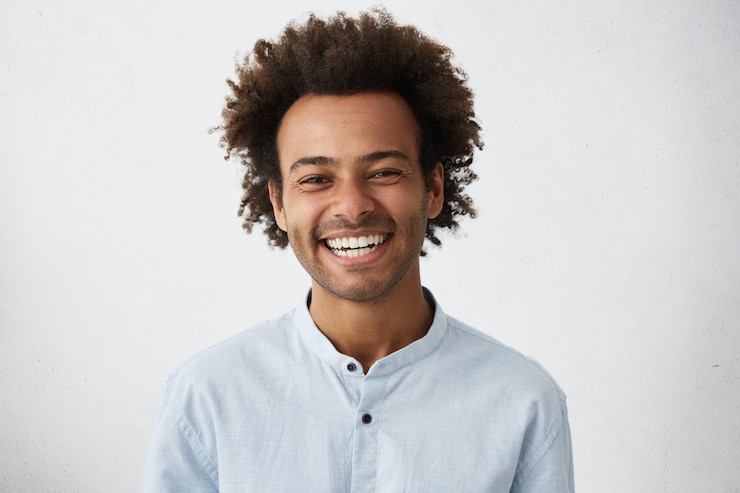 Photo gratuit amical à l'homme élégant afro-américain positif avec des cheveux et des poils funky souriant largement