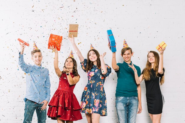 Amies adolescentes gaies jetant des confettis à la fête d&#39;anniversaire