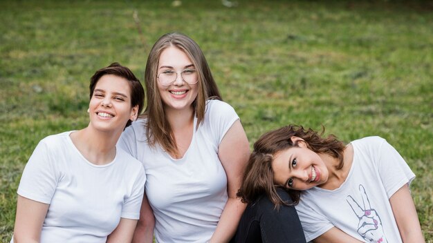 Amies assis sur l&#39;herbe en souriant