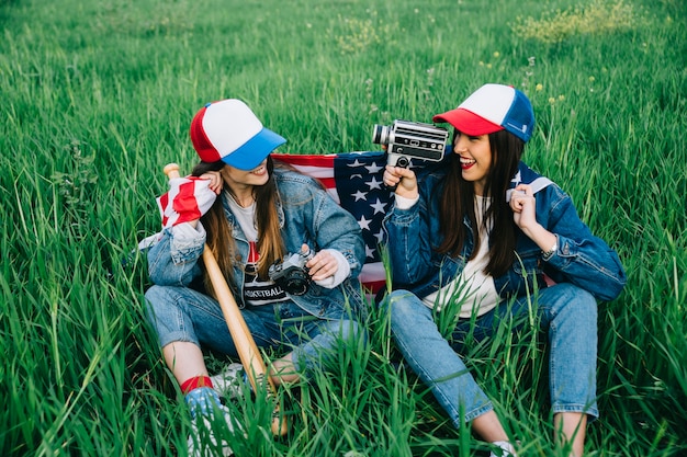 Amies assis sur l&#39;herbe verte dans des vêtements décontractés