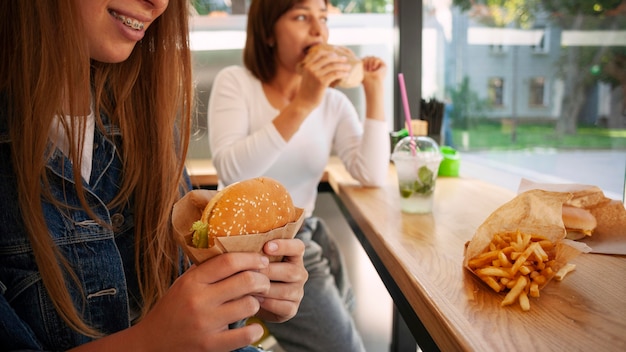 Amies ayant un hamburger ensemble