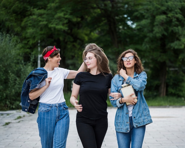 Photo gratuite amies marchant ensemble sur le trottoir du parc