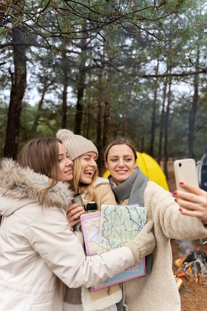 Photo gratuite amies prenant un selfie avec une carte en camping