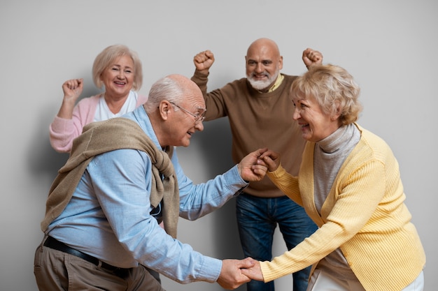 Photo gratuite amis aînés dansant ensemble plan moyen