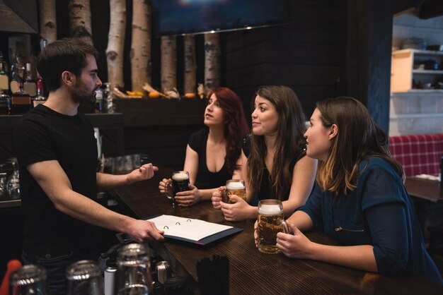 Amis assis au comptoir du bar