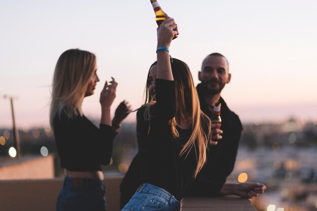 Amis, boire de la bière sur le toit