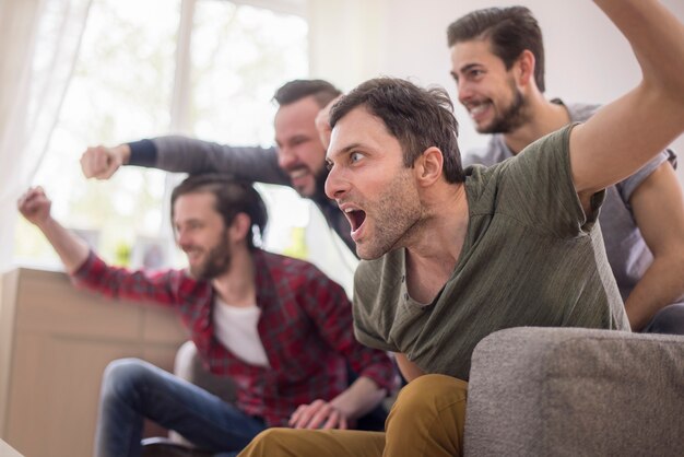 Amis buvant de la bière et regardant un match de football