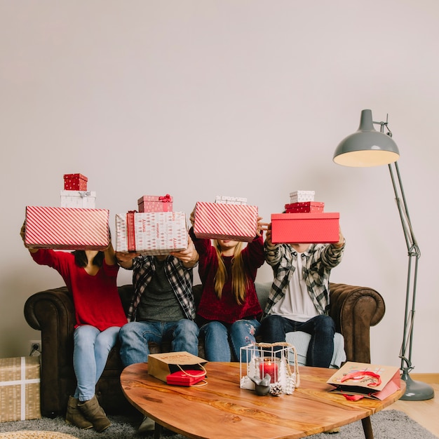 Photo gratuite amis sur le canapé soulevant des cadeaux