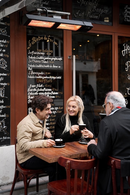 Photo gratuite amis à coup moyen assis ensemble au bistro