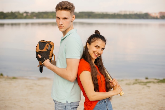 Amis à coup moyen posant avec un équipement de baseball