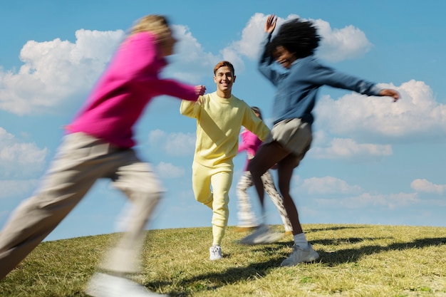 Photo gratuite amis courir ensemble sur un terrain à l'extérieur