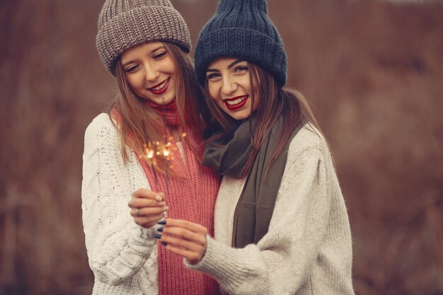 Amis dans un parc d'hiver. Filles dans un chapeau tricoté. Femmes avec des cierges.