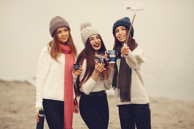 Amis dans un parc d'hiver. Filles dans un chapeau tricoté. Les femmes avec thermos et thé.