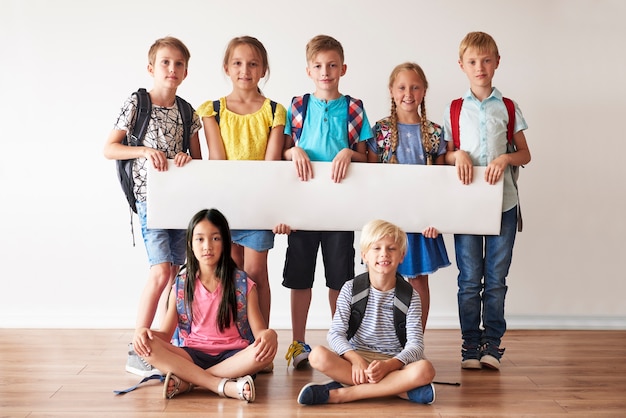 Amis de l'école avec une pancarte blanche