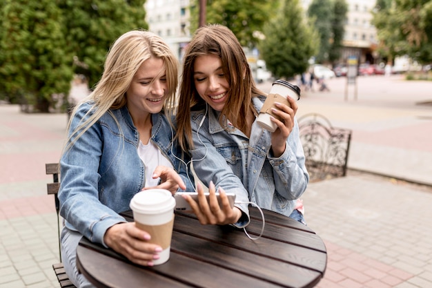 Amis écoutant de la musique tout en tenant des tasses de café