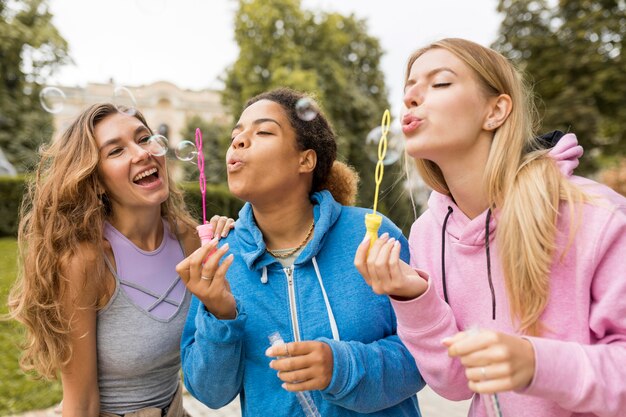 Amis faisant des bulles de savon dans le parc