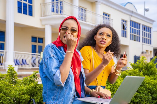 Amis faisant du shopping en ligne assis dans un parc