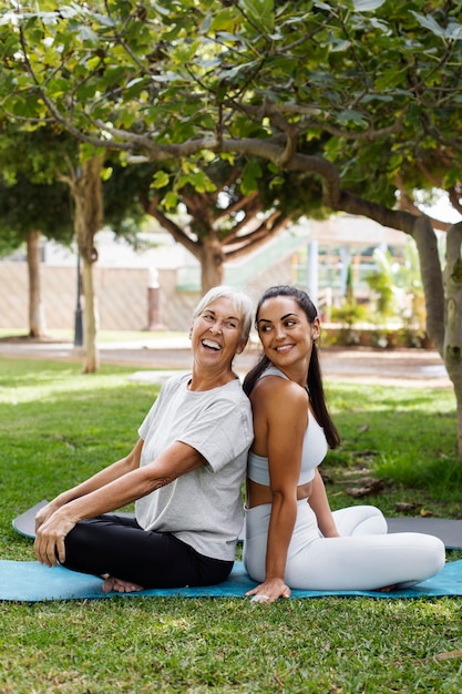 Photo gratuite amis faisant du yoga ensemble dans le parc