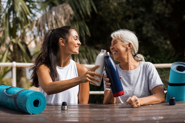 Photo gratuite amis faisant du yoga ensemble dans le parc